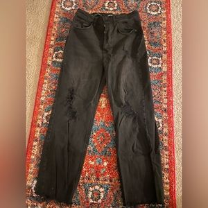 Womens black jeans with holes in the knees and fringed at the bottom. Size 8.